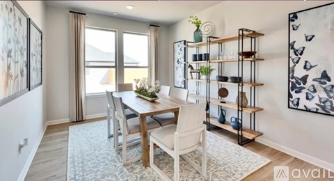 A dining room with a table set for two and a view of the backyard.