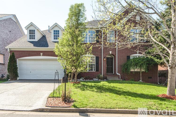 A house with a white garage door and a brick facade.