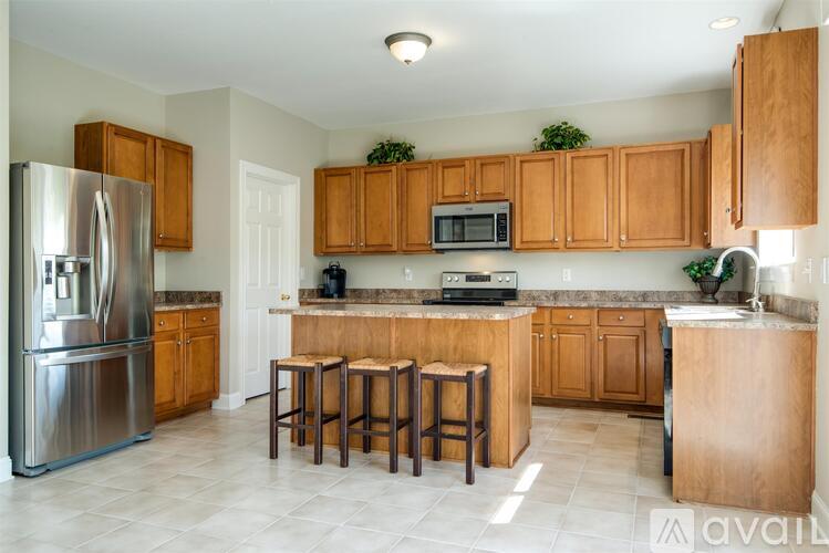 A kitchen with wooden cabinets and a refrigerator.