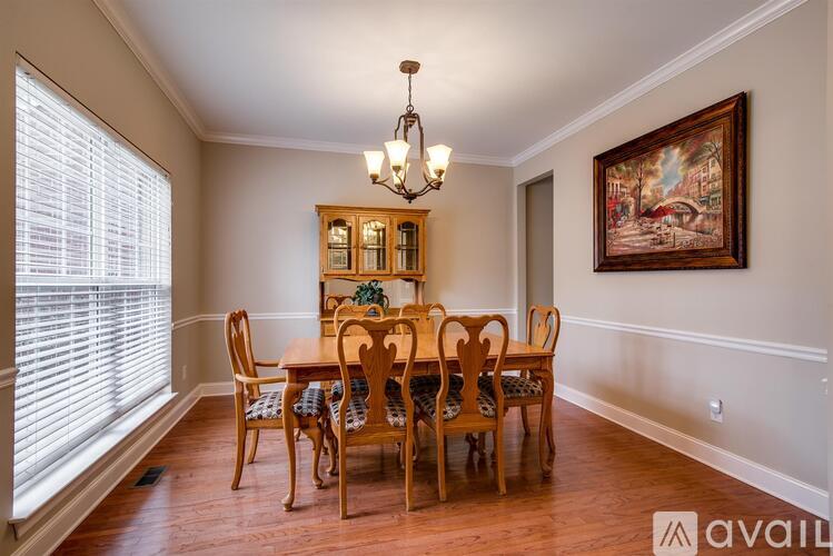 A dining room with a wooden table and chairs.