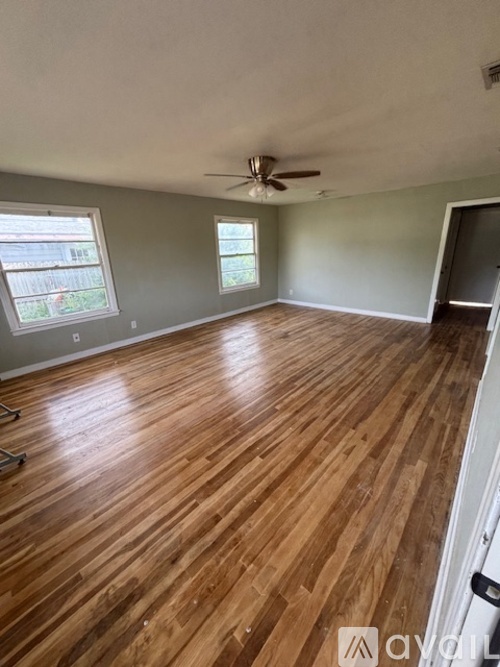A room with wooden flooring and a ceiling fan.