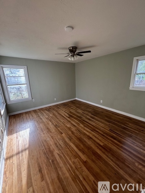 A room with wooden flooring and a ceiling fan.