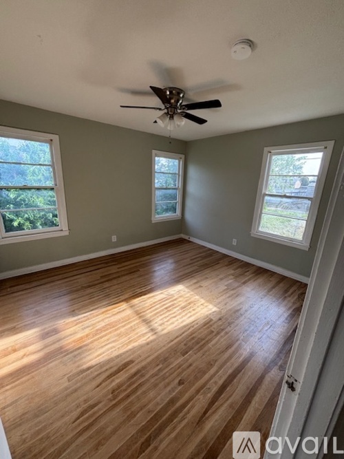 A room with wooden floors and a ceiling fan.