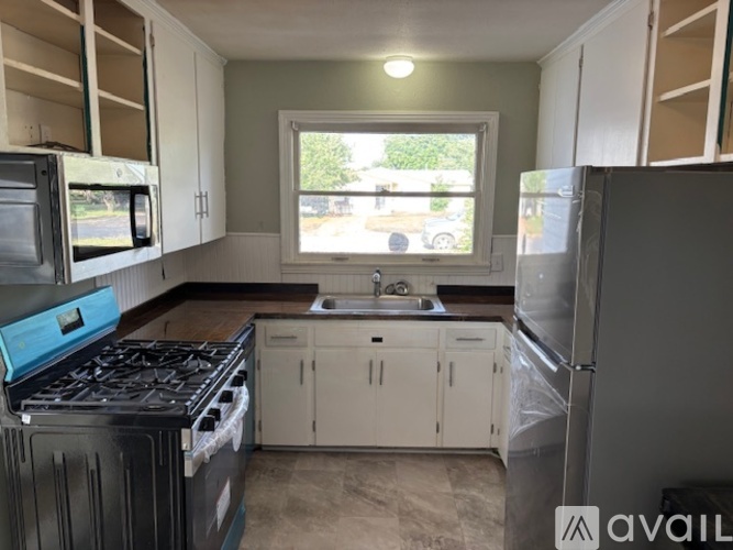 A kitchen with a black stove top oven and white cabinets.
