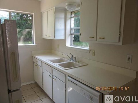 A kitchen with white cabinets and a white sink.