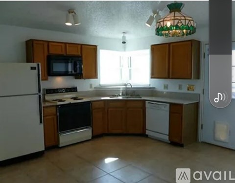 A kitchen with wooden cabinets and a white refrigerator.