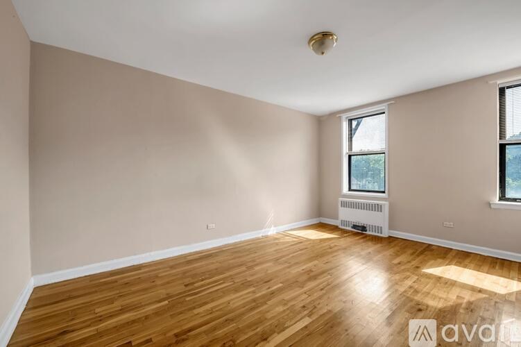A room with wooden floors and a window with blinds.