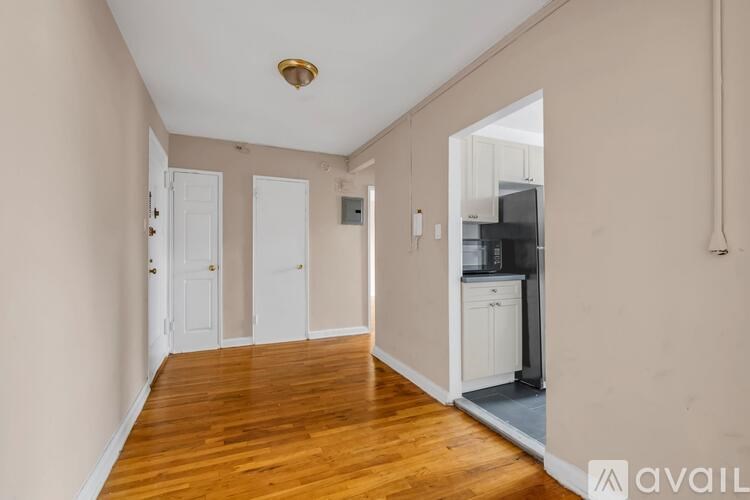 A long hallway with a kitchen area visible in the distance.