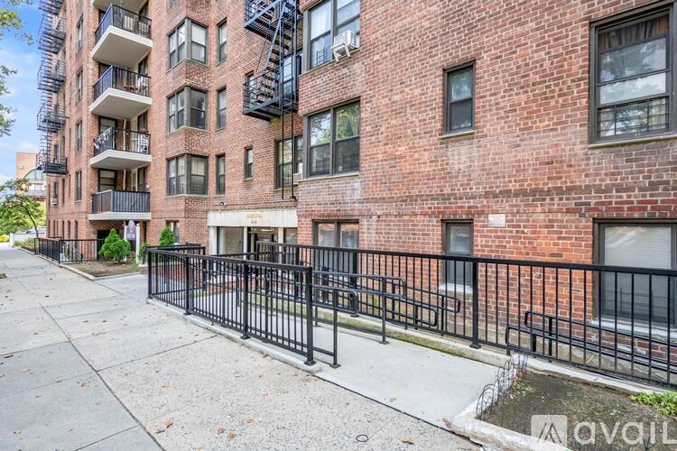 A brick building with a black fence in front.