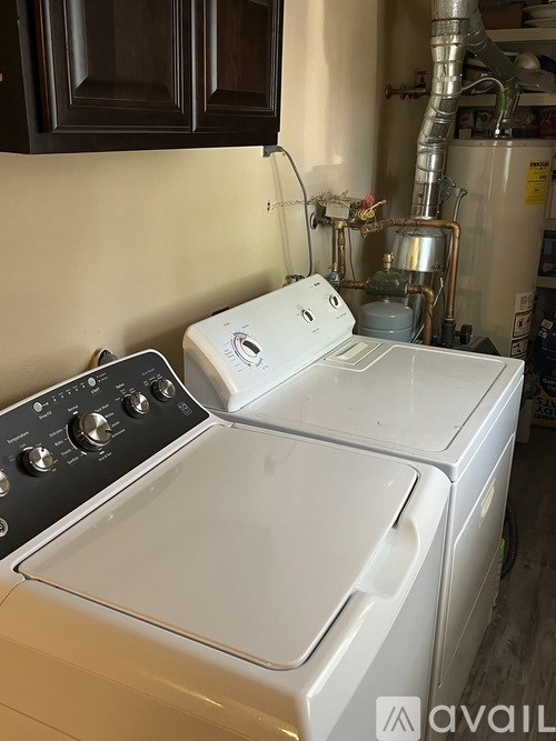 A white washing machine sits in front of a wall.