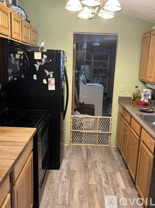 A kitchen with black appliances and wooden cabinets.