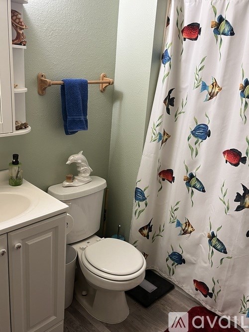 A white toilet with a blue towel hanging on a towel rack in a bathroom.
