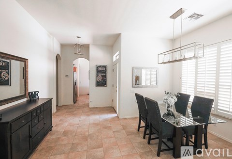 A kitchen with a table and chairs in the foreground and a hallway in the background.