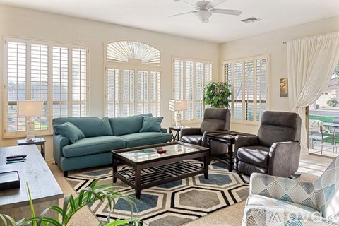 A living room with a glass table and a couch.