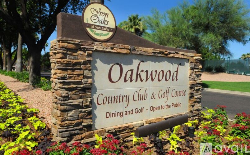 A sign for Oakwood Country Club & Golf Course with a logo on the top left.