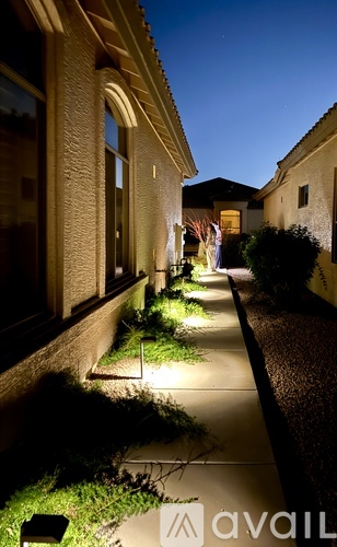 A narrow alleyway with lights on the sides and a building on the left.