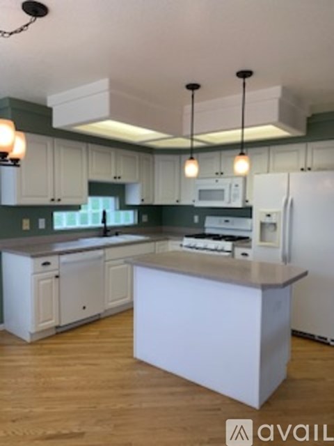 A kitchen with white cabinets and a white island.