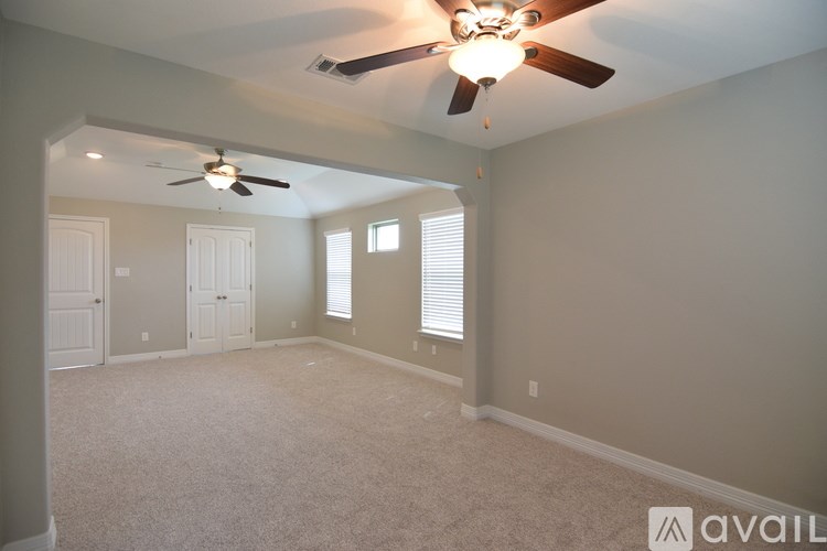 A room with a ceiling fan and carpeted floor.