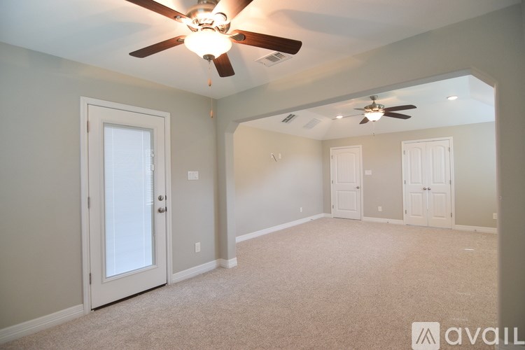 A room with a ceiling fan and carpeted floor.