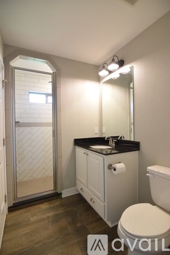 A bathroom with a toilet, sink, and mirror.