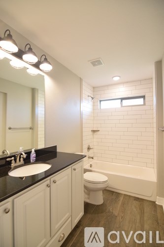 A bathroom with a sink, toilet and tub.
