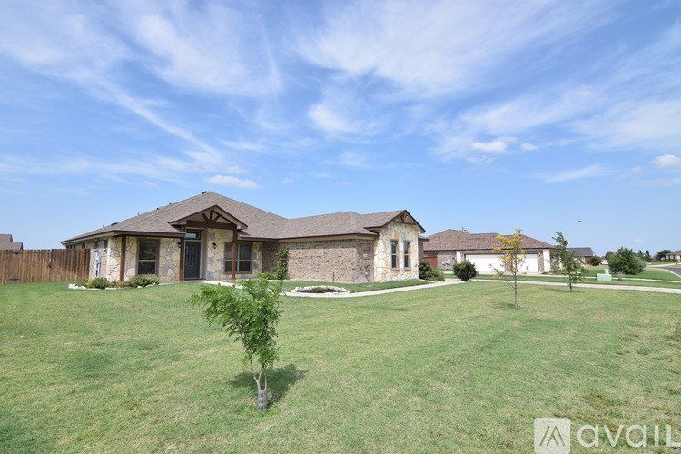 A house with a lawn and a tree in front of it.
