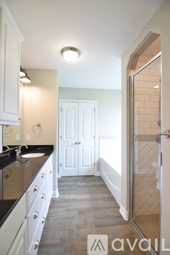A kitchen with white cabinets and a black counter top.