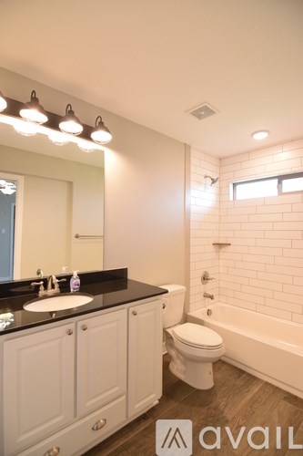 A bathroom with a sink, toilet, and bathtub.