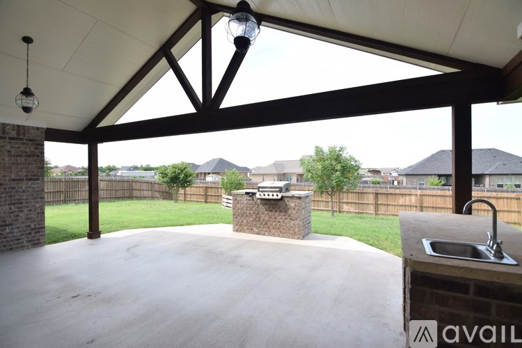 A patio with a brick pillar and a hanging light fixture.