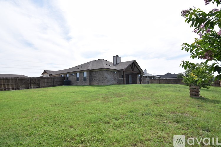 A house with a fence and a green lawn in front.