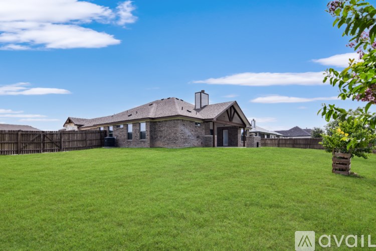 A house with a fence and a tree in front of it.