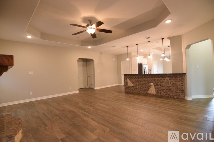 A spacious room with a ceiling fan and wooden flooring.