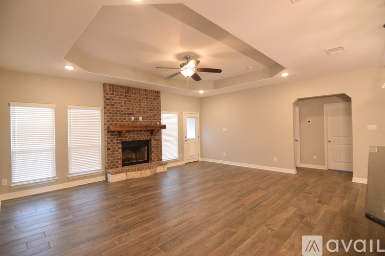 A spacious living room with a fireplace and wood flooring.