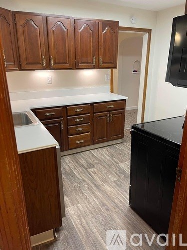 A kitchen with wooden cabinets and a black countertop.