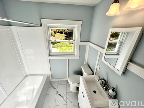 A bathroom with a tub, toilet, and sink.