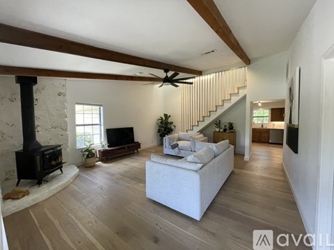 A living room with a white couch and a wood burning stove.