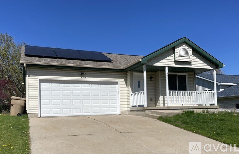 A house with a white garage door and a solar panel on the roof.