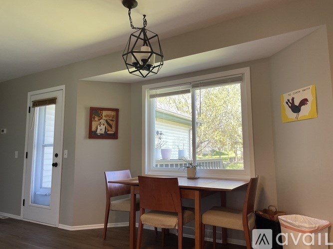A dining room with a table and chairs.