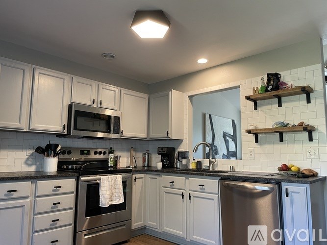 A kitchen with white cabinets and stainless steel appliances.