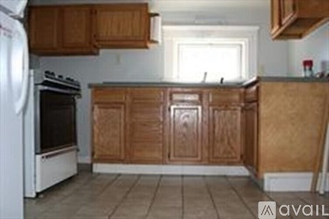 A kitchen with wooden cabinets and a white refrigerator.