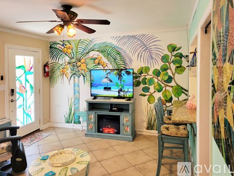 A living room with a television and a fan.