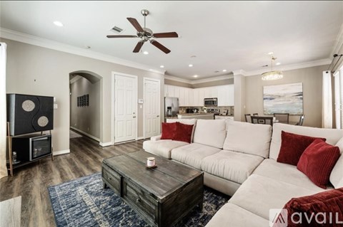 A living room with a white couch and a ceiling fan.