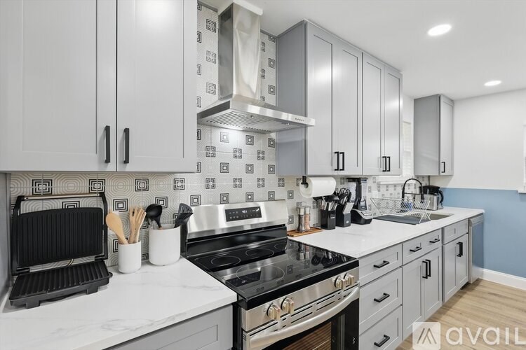 A kitchen with a black stove top oven and white cabinets.