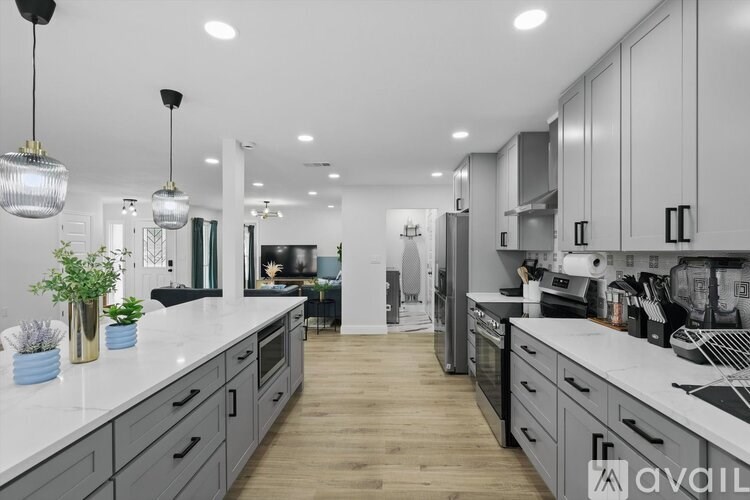 A modern kitchen with a long counter and stainless steel appliances.