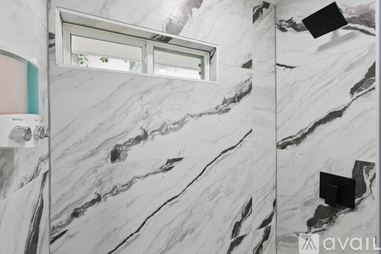 A bathroom with marble walls and a window.