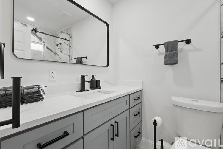 A bathroom with a white tub and a mirror above the sink.