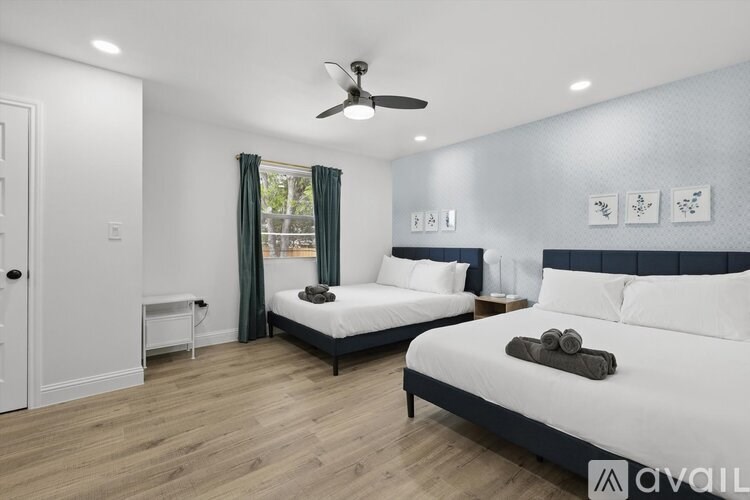 A bedroom with two beds and a ceiling fan.