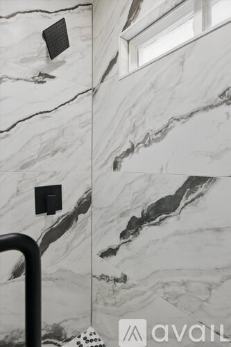 A bathroom with marble walls and a window.