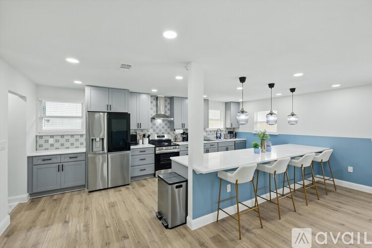 A modern kitchen with a bar area and stainless steel appliances.
