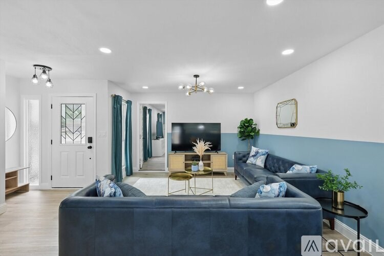 A living room with a dark blue sofa and a wooden coffee table.